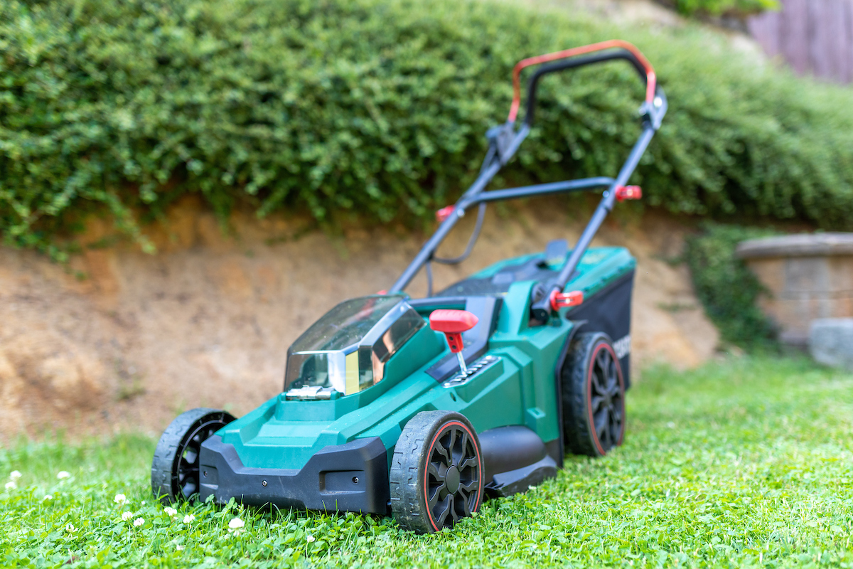 Modern cordless battery electric lawn mowers in the garden